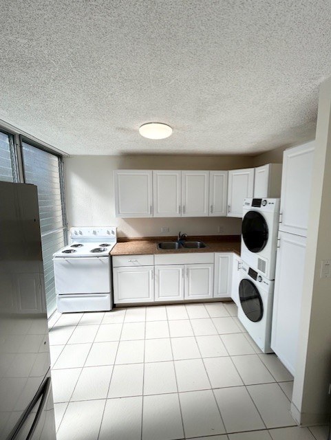 A white kitchen with a refrigerator, oven, dishwasher, and washing machine.